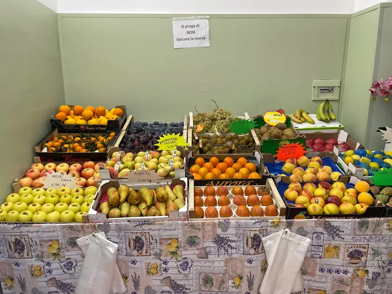 Bancone della frutta di Orto in Piazza: mele, pere, arance, prugne, uva, cachi e pesche